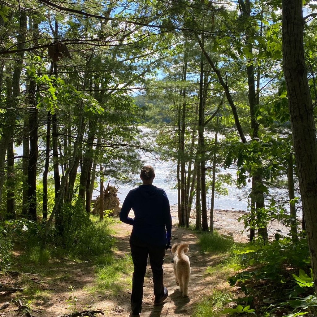 woman dog hiking waterfront 